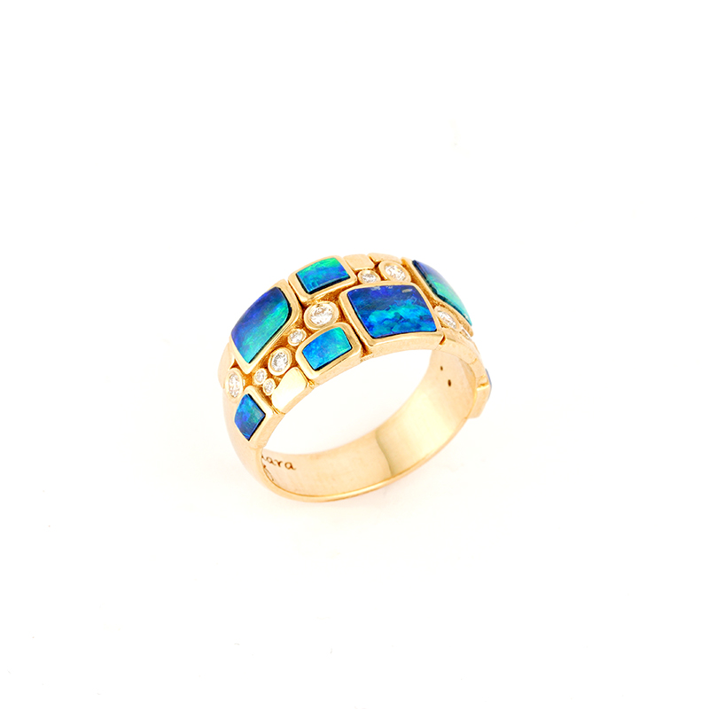 Gold ring by Navajo jewelry designer Mia Zaara Hamdouni, featuring geometric blue opal inlay and round diamond accents set in polished yellow gold, photographed on a white background.