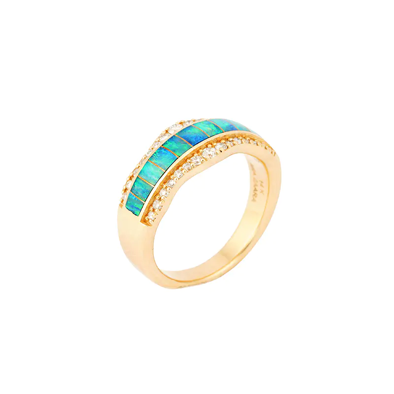 Three-quarter view of a 14k gold ring by Navajo jewelry designer Mia Zaara Hamdouni, featuring a curved band of segmented blue opal inlay across the top and a row of diamond accents set into a polished gold band.