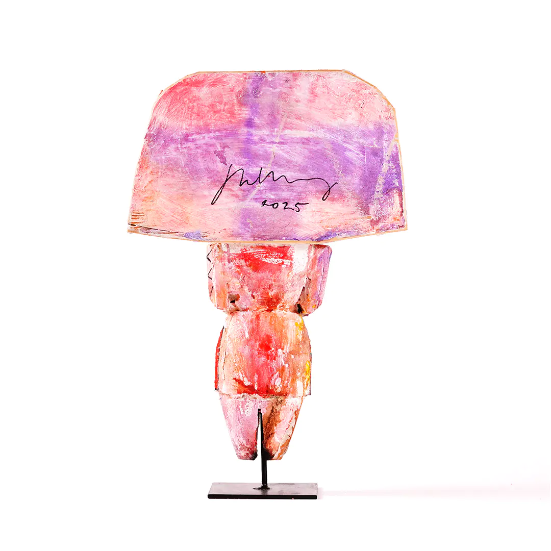 Sheldon Harvey Yei wood sculpture, rear view, hand-painted in pink and purple tones with the artist’s signature and date on the back, mounted on a black metal base. Year made: 2025.