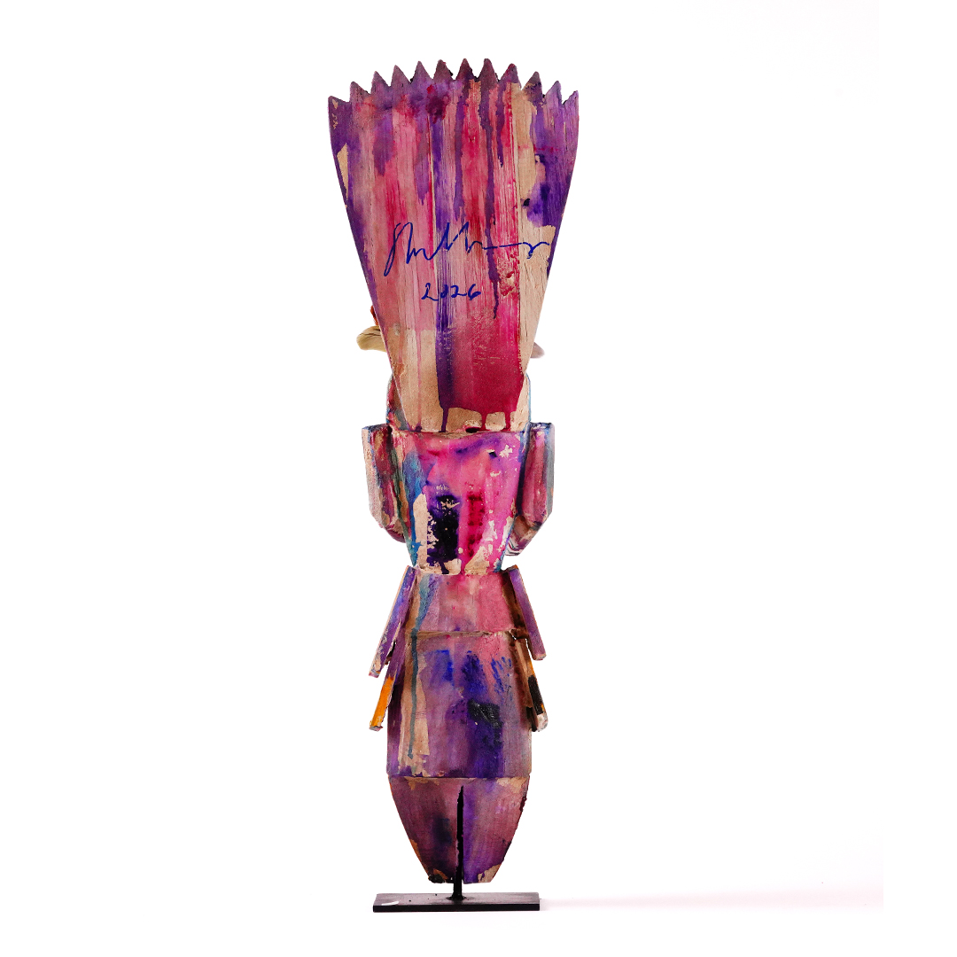 Abstract upright sculpture painted in vivid pink, purple, and red tones, with a jagged crown-like top, blocky geometric body, and narrow pedestal base against a white background.