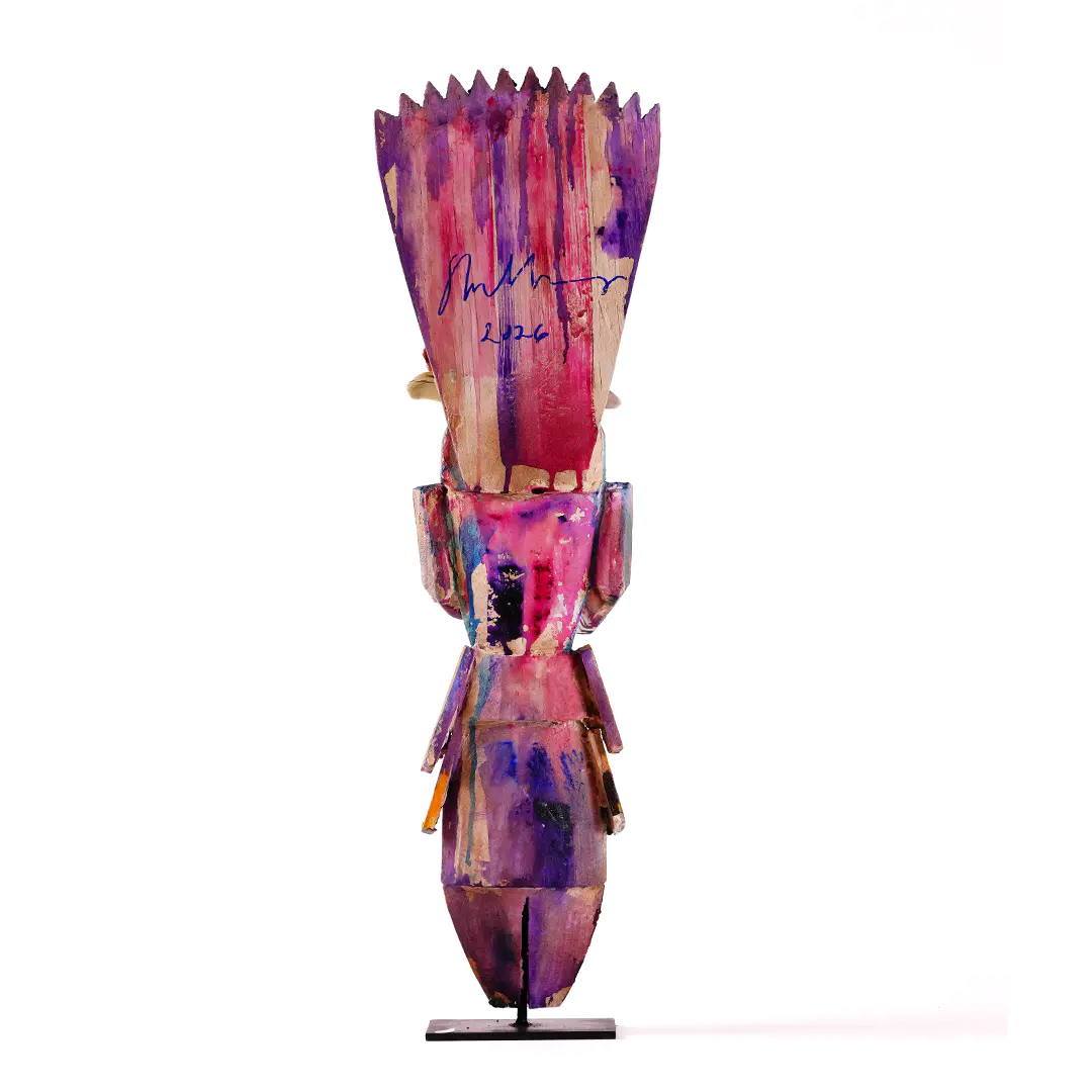 Abstract upright sculpture painted in vivid pink, purple, and red tones, with a jagged crown-like top, blocky geometric body, and narrow pedestal base against a white background.