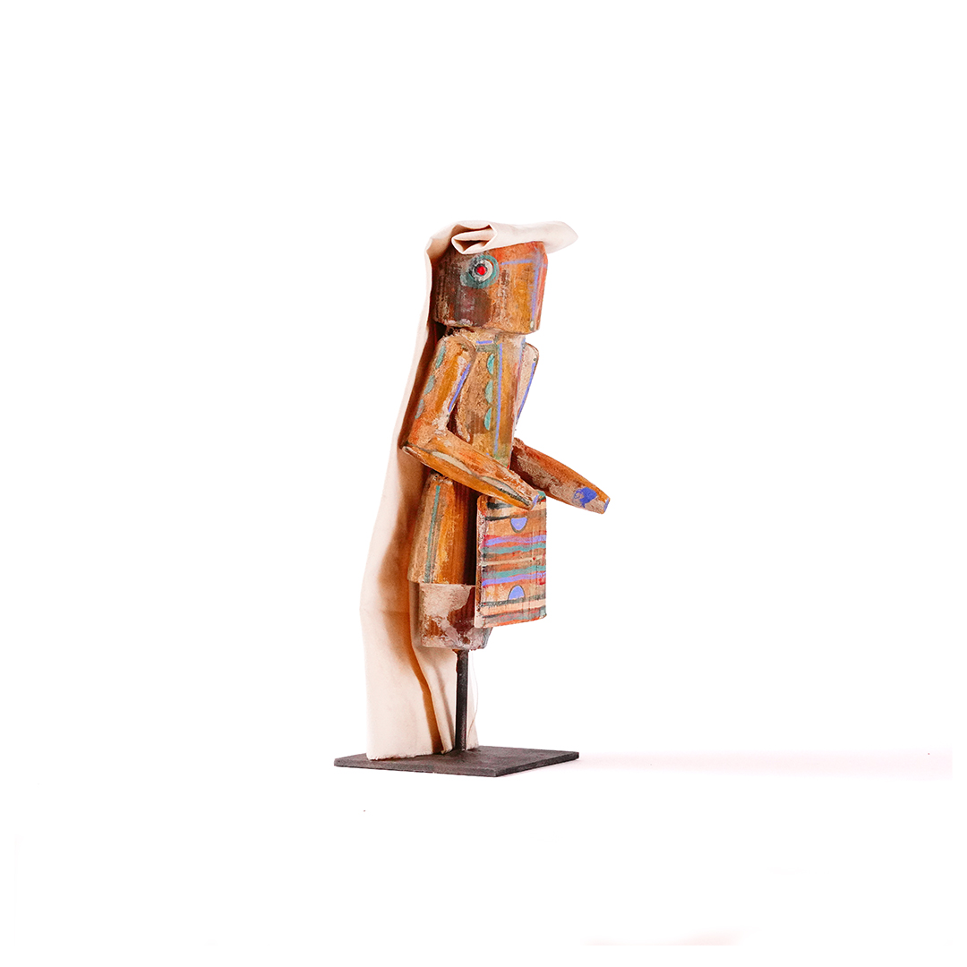 Small wood Yei sculpture by Sheldon Harvey, side view, with canvas headdress and metal base.