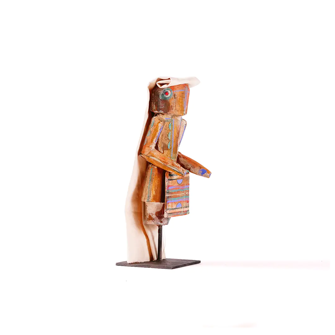 Small wood Yei sculpture by Sheldon Harvey, side view, with canvas headdress and metal base.