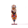 Small stylized Yei sculpture by Sheldon Harvey with painted geometric details, cloth wrap, feathers, and metal base.